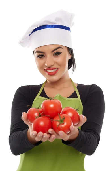 Женщина-повар предлагает свежесобранные помидоры — стоковое фото