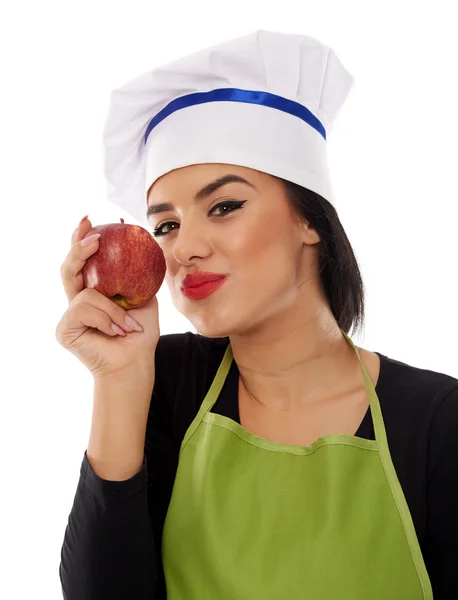 Mulher chef comer maçã vermelha — Fotografia de Stock