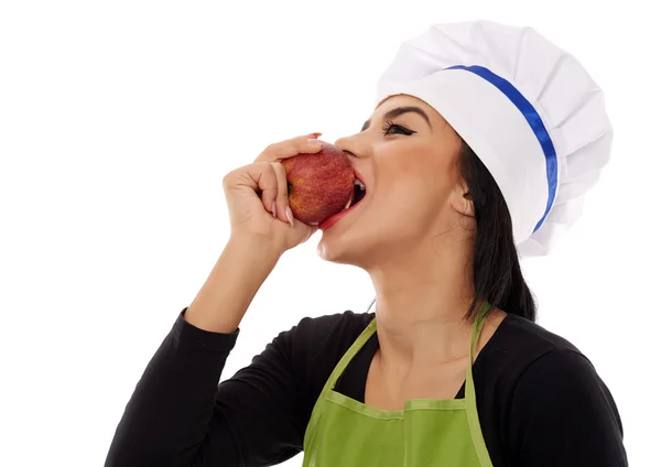 Woman chef eating red apple — Stock Photo, Image