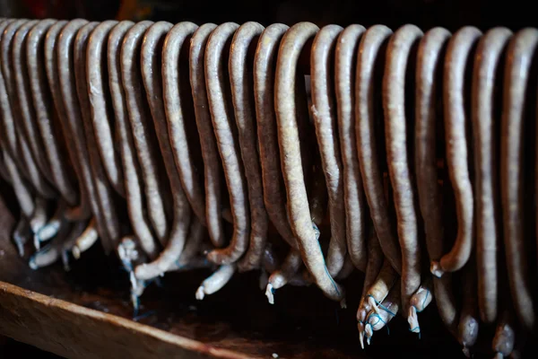 Homemade pork sausages hanging in the smokehouse — Stock Photo, Image