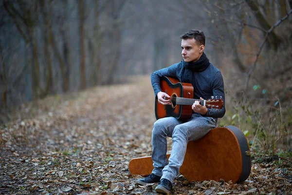 Gitarist zingen buiten in het bos — Stockfoto