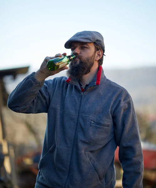 Agricultor bebiendo una botella de cerveza — Foto de Stock