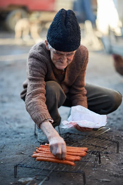 Homem preparando salsichas — Fotografia de Stock