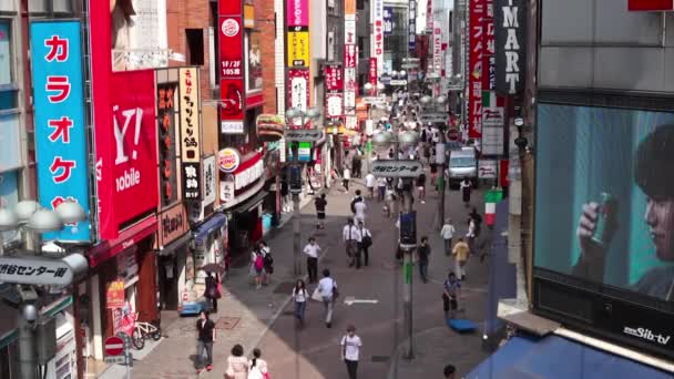 Människor korsar Shibuya korsningen i Tokyo — Stockvideo