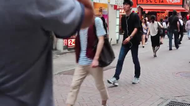 Mensen steken de Shibuya kruising in Tokio over — Stockvideo