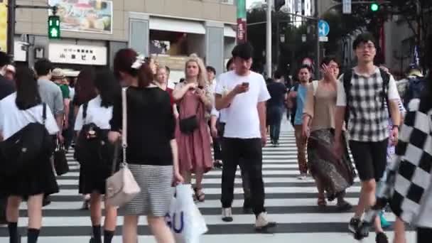 Pessoas atravessam o cruzamento Shibuya em Tóquio — Vídeo de Stock