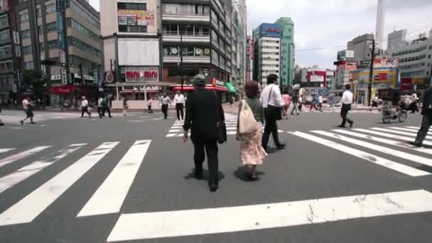 Menschen überqueren die berühmte Shibuya-Kreuzung in Tokio — Stockvideo