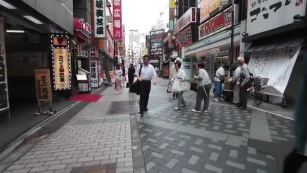 Personer passera berömda Shibuya korsningen i Tokyo — Stockvideo