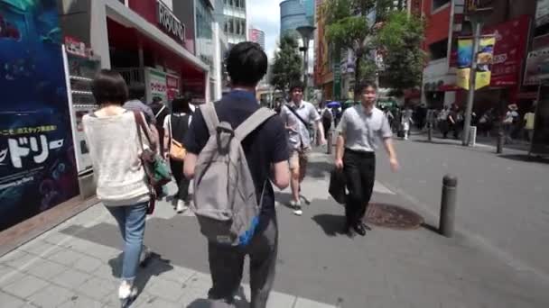 Pessoas atravessam o famoso cruzamento Shibuya em Tóquio — Vídeo de Stock