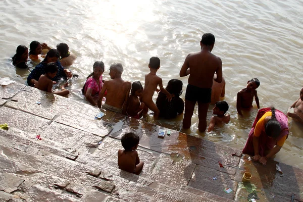 As pessoas vagueiam na água durante uma cerimônia religiosa — Fotografia de Stock