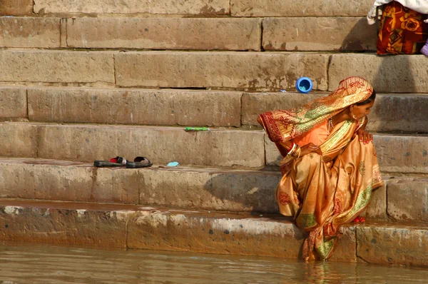 Женщина в сари у реки — стоковое фото