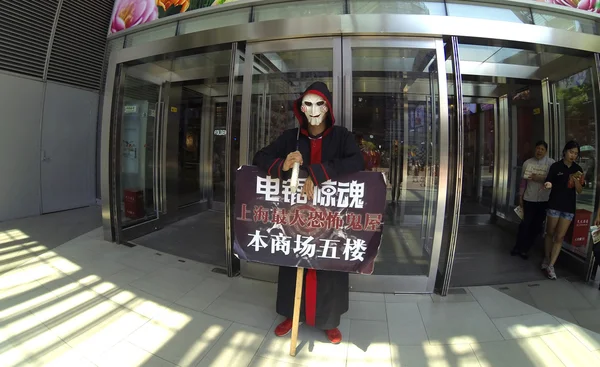 Un hombre con una máscara con un cartel en la entrada del hotel — Foto de Stock