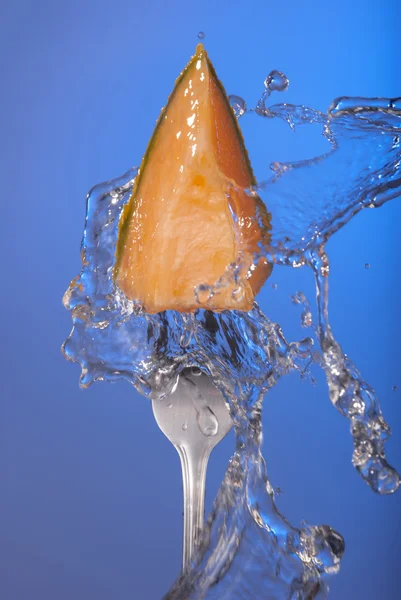 Meloen fruit meloen vork blauwe achtergrond water — Stockfoto
