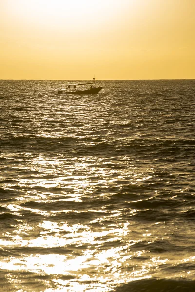 Pôr do sol sobre a água do oceano com barco no horizonte — Fotografia de Stock