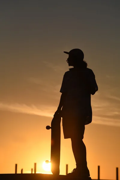 Giovanissima ragazzo silhouette con skateboard su estate giorno — Foto Stock