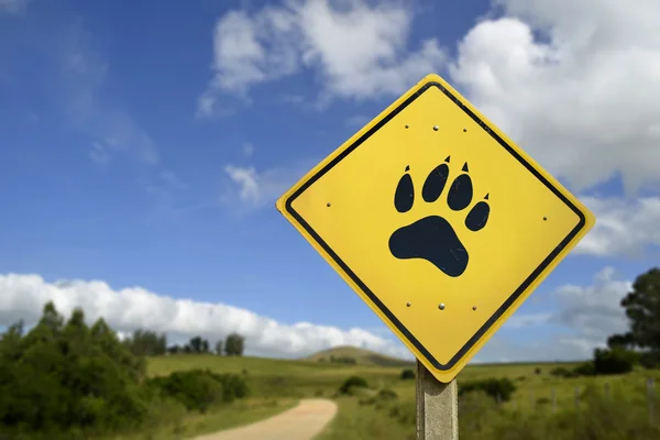 Conceito de animal de vida selvagem com ícone de pata no sinal de estrada — Fotografia de Stock