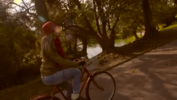 Menina andar de bicicleta no parque no outono câmera lenta — Vídeo de Stock