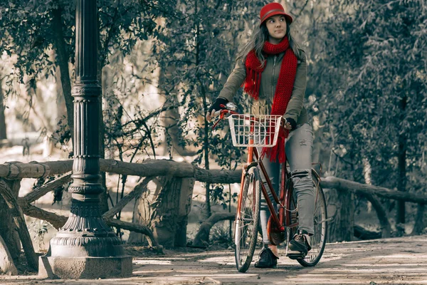 Young woman riding red vintage bike on fall season — Stock Photo, Image