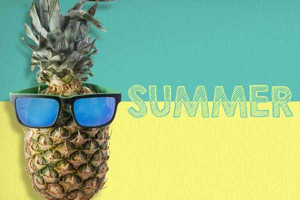 Pineapple wearing sunglasses on summer background