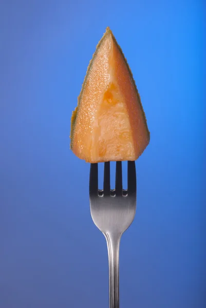 Melão fruta cantaloupe garfo azul fundo saúde — Fotografia de Stock