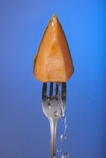 Melão fruta cantaloupe garfo azul fundo água — Fotografia de Stock