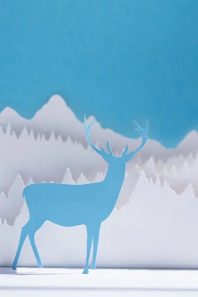 Papper skär rådjur handgjorda hantverk blå julkort — Stockfoto