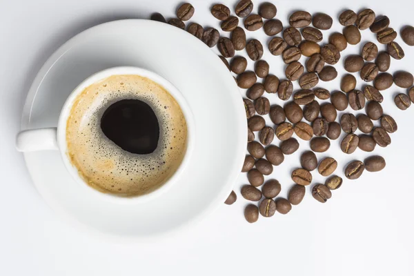 Kopje koffie met schuim en geroosterde bonen — Stockfoto