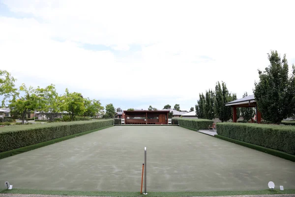 View of lawn bowls green and pavillon and equipment at far end, Victoria, Australia