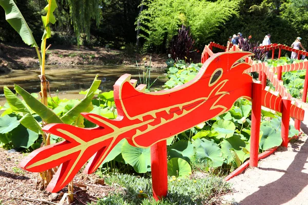 Dragón Rojo Brillante Que Forma Parte Una Cerca Jardín Lirios — Foto de Stock