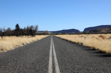 Alice Springs, Kuzey Bölgesi, Avustralya 'nın dışındaki çarpıcı MacDonnell Sıradağları. Uzun yolları ve uzak dağları olan açık düzlükleriyle.
