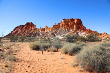 Kuzey Bölgesi, Avustralya 'daki İnanılmaz Gökkuşağı Vadisi, Alice Springs' in hemen dışında. Mavi gökyüzü ve turuncu kumlarla güzel kırmızı ve turuncu kaya oluşumu
