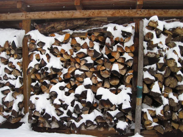 Stack of firewood covered by snow — Stock Photo, Image