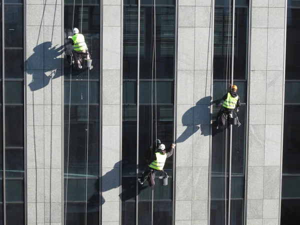 Washers wash the windows of modern skyscraper — Stock Photo, Image