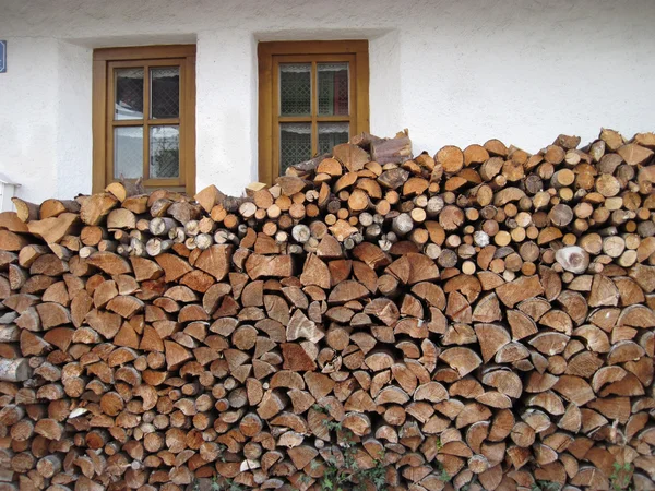 Firewood is lying under the windows — Stock Photo, Image