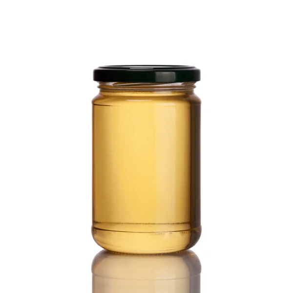 Medová sklenice na bílém pozadí — Stock fotografie