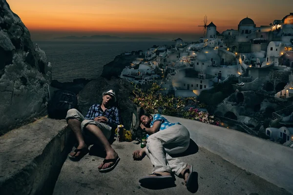 Turister med ryggsäckar sova på byn Oia — Stockfoto