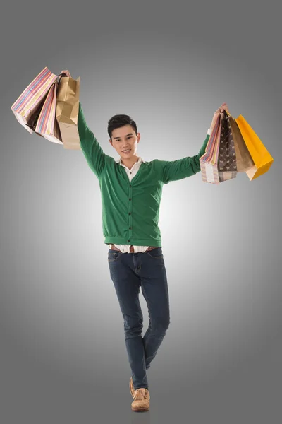 Asian young man holding shopping bags — Stock Photo, Image