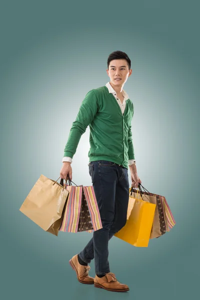 Asian young man holding shopping bags — Stock Photo, Image