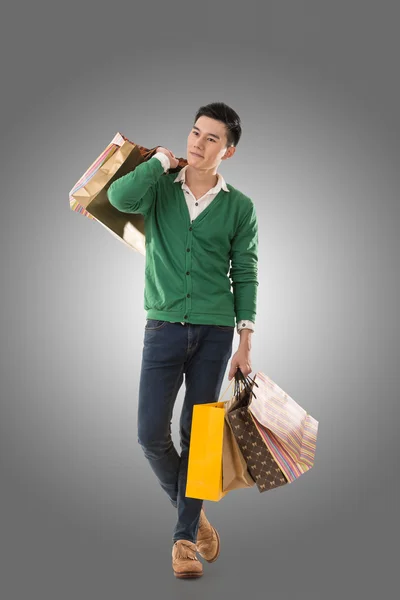 Asian young man holding shopping bags — Stock Photo, Image