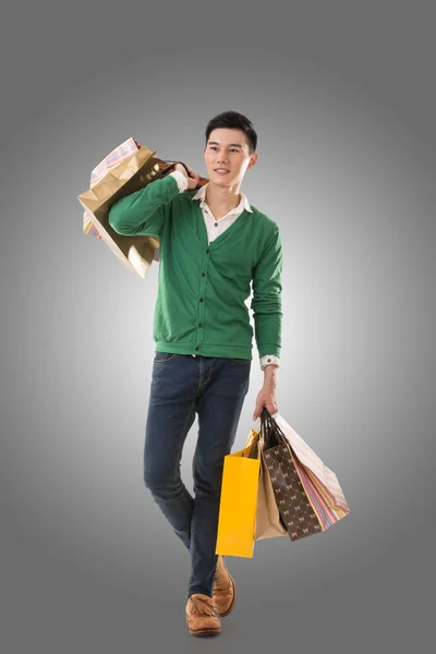 Asian young man holding shopping bags — Stock Photo, Image