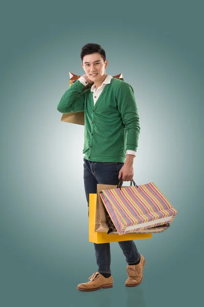 Asian young man holding shopping bags — Stock Photo, Image