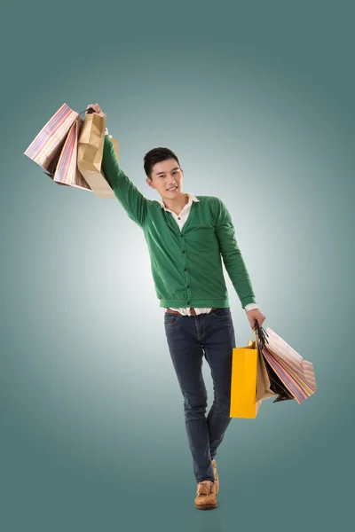 Asiático jovem segurando sacos de compras — Fotografia de Stock