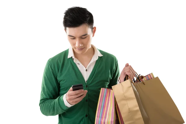 Holding shopping bags and using cellphone — Stock Photo, Image