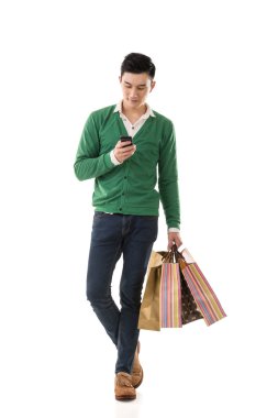 alışveriş torbaları tutarak ve cep telefonu kullanarak