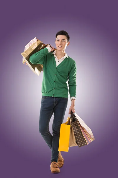 Asian young man holding shopping bags — Stock Photo, Image