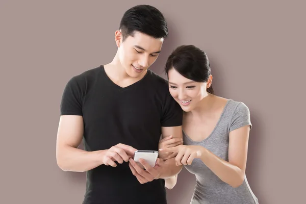 Couple shopping and looking at cellphone — Stock Photo, Image
