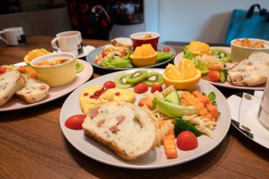 Sabah bir tabakta ekmek, sebze ve meyve kahvaltısı.