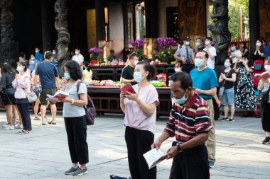 Taipei, Tayvan - 4 Ekim 2020: İnsanlar Tayvan 'daki Wanhua Lung Shan Tapınağında tütsü çubukları tutup dua ediyorlar.