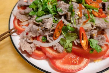 Dilimlenmiş domates ve soğan üzerine domuz eti aperatifi.