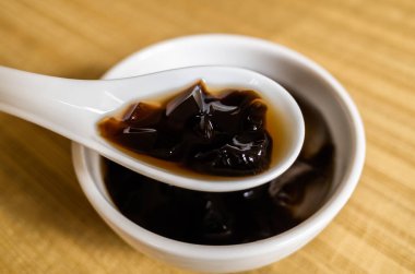 Geleneksel Tayvan atıştırmalıkları. Bir kâsede siyah bitki çayı.
